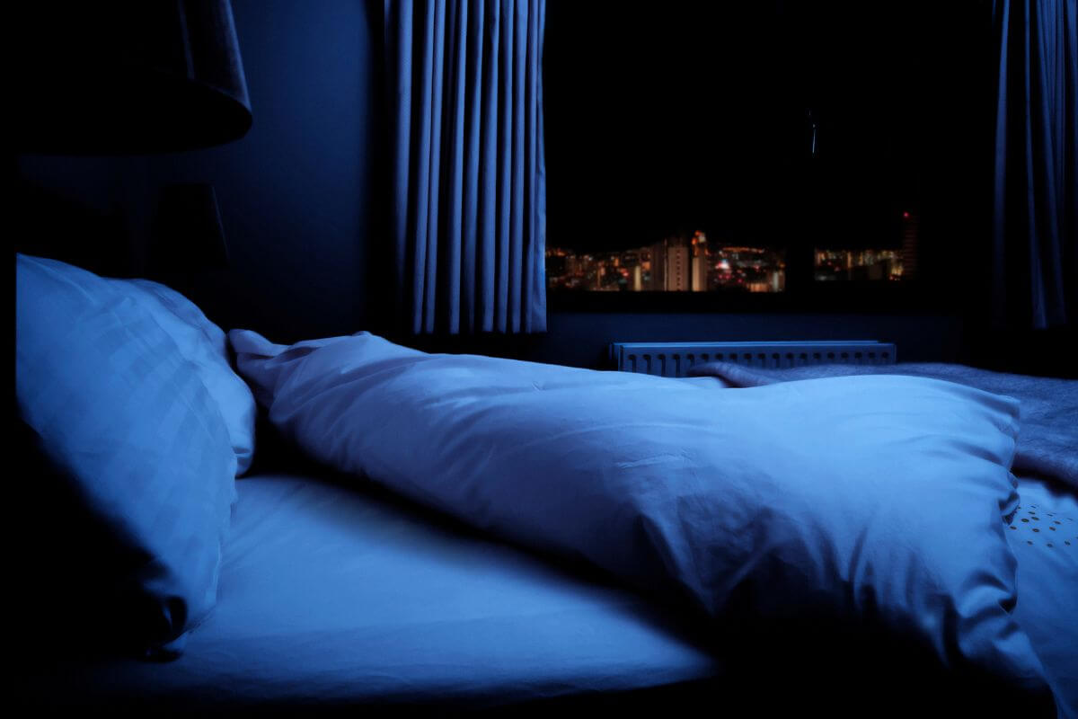 Empty bed and dark bedroom at night, representing night time anxiety and sleeplessness