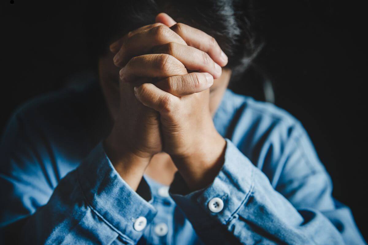 Hands clasped in prayer during a quiet night, seeking God's comfort and peace from anxiety at 2 a.m.