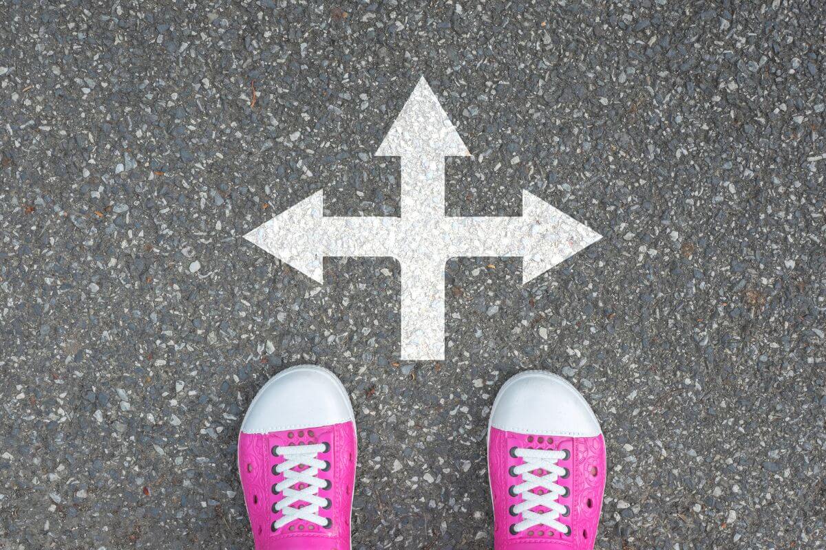 Person standing at a crossroads with arrows pointing in different directions, symbolizing how to trust God with the future when tomorrow feels uncertain.