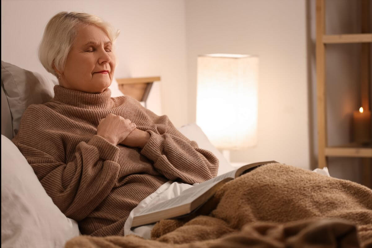 Senior woman praying while reading Bible verses for anxiety at night