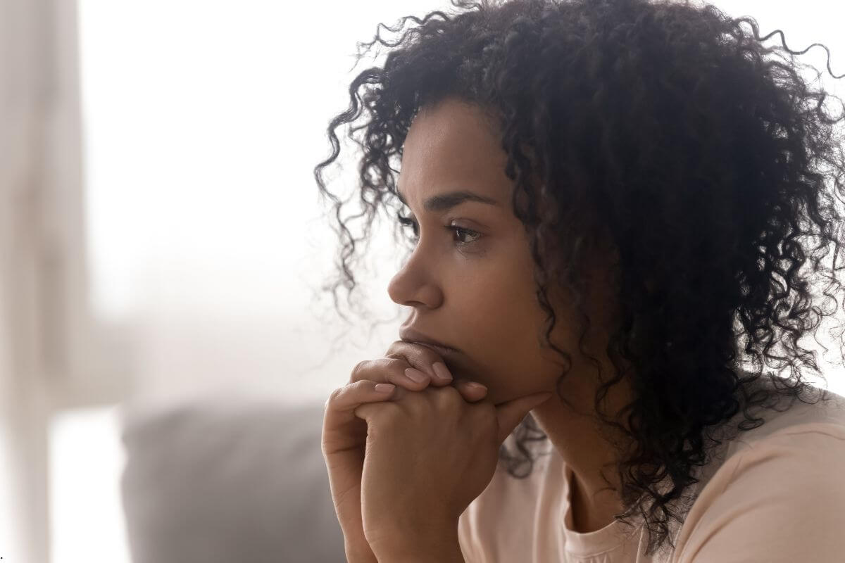Woman lost in anxious thoughts, illustrating how to stop overthinking by recognizing the mental trap that keeps the mind consumed with worry instead of trusting God.