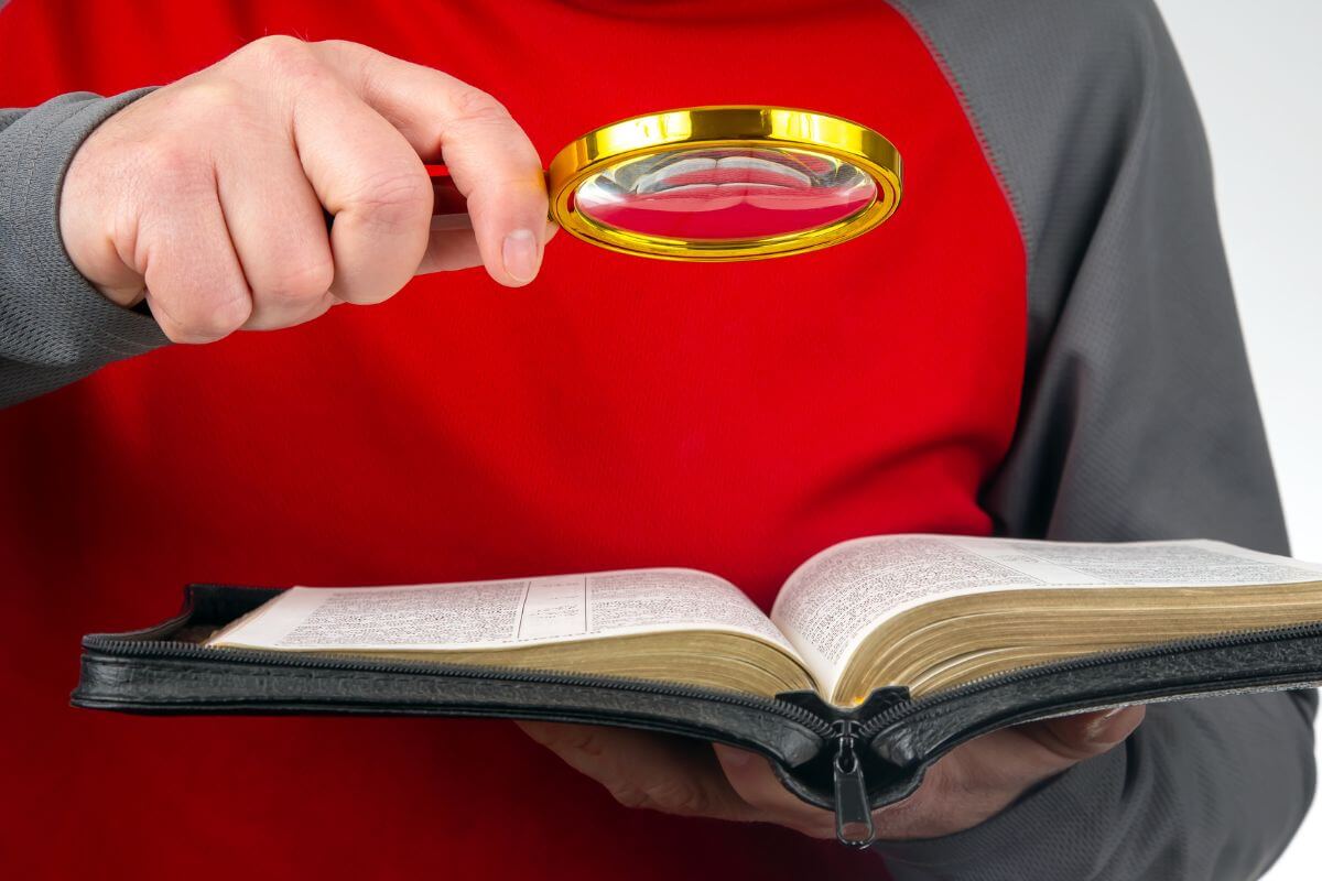 A magnifying glass over an open Bible, symbolizing a closer look at Bible verses for fear and the comfort found in God's Word.