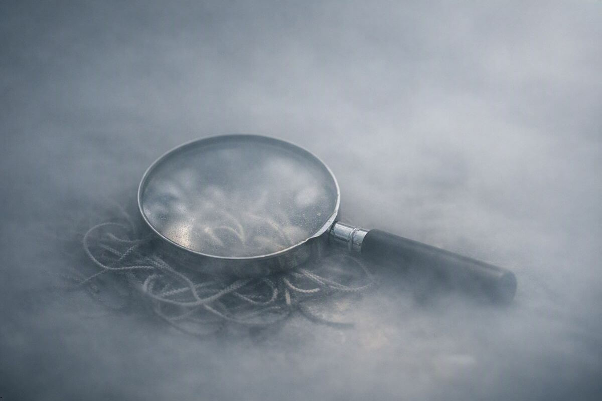 Magnifying glass over tangled lines in mist, symbolizing how overthinking never brings clarity