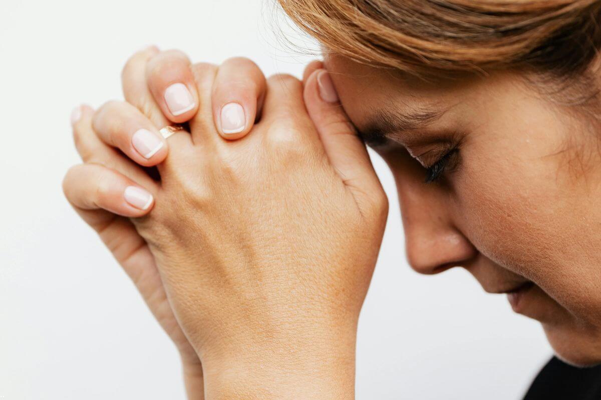 Woman praying as she chooses to give her worries to God and trust Him with every burden.